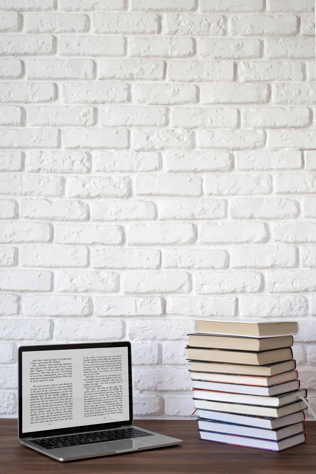 Laptop und Bücher auf einem Tisch angeordnet