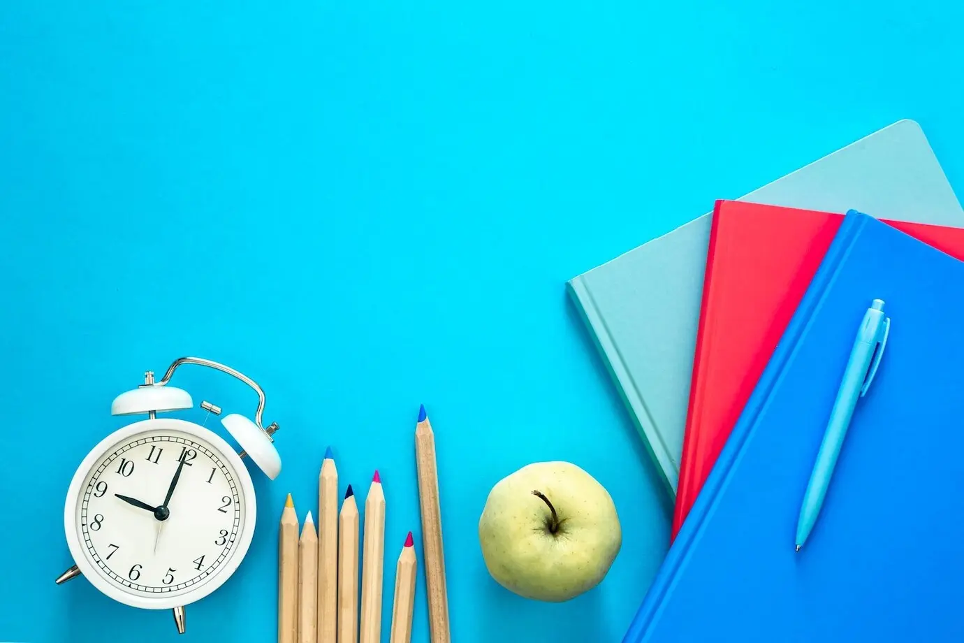 Komposition in Draufsicht mit farbenfrohen Lernmaterialien auf blauem Hintergrund